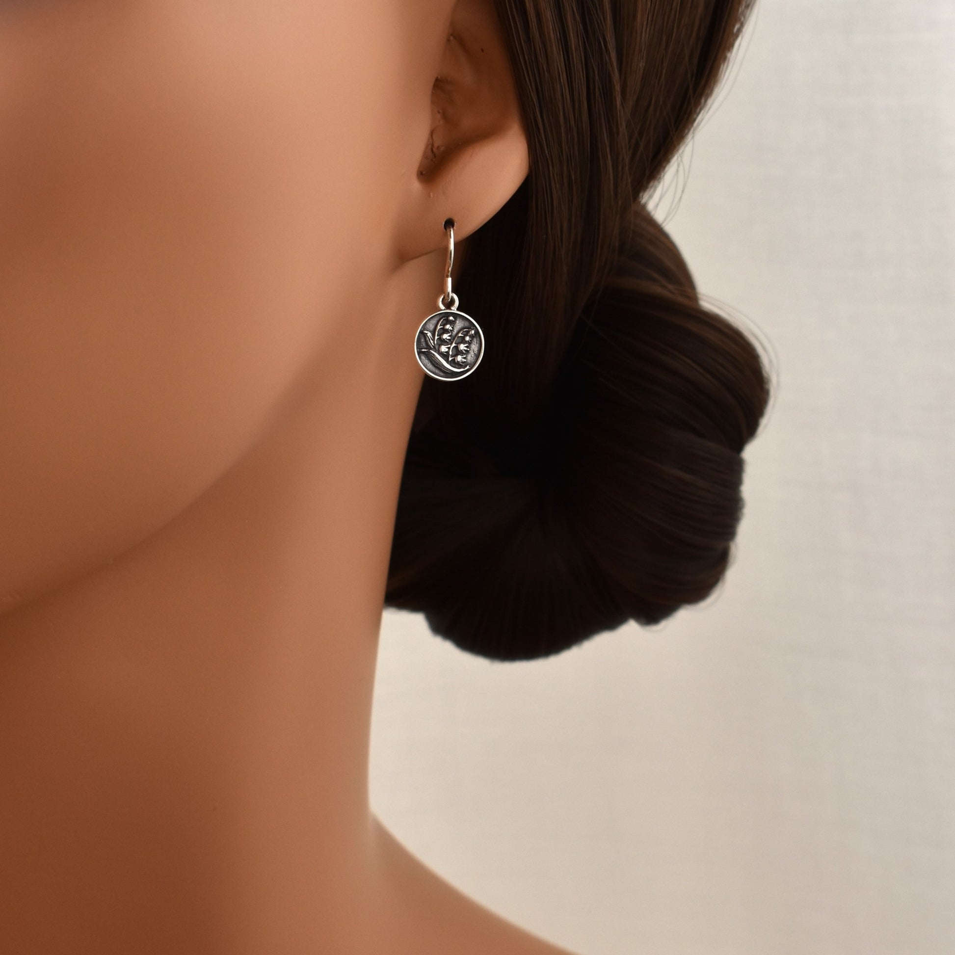 Lilly of the valley flower drop earrings. Floral dangle earrings shown on model.