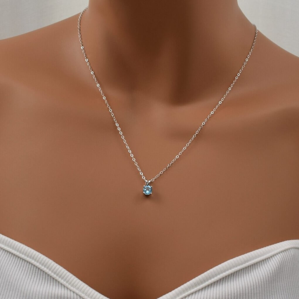 Swiss blue topaz necklace with sterling silver chain shown model.