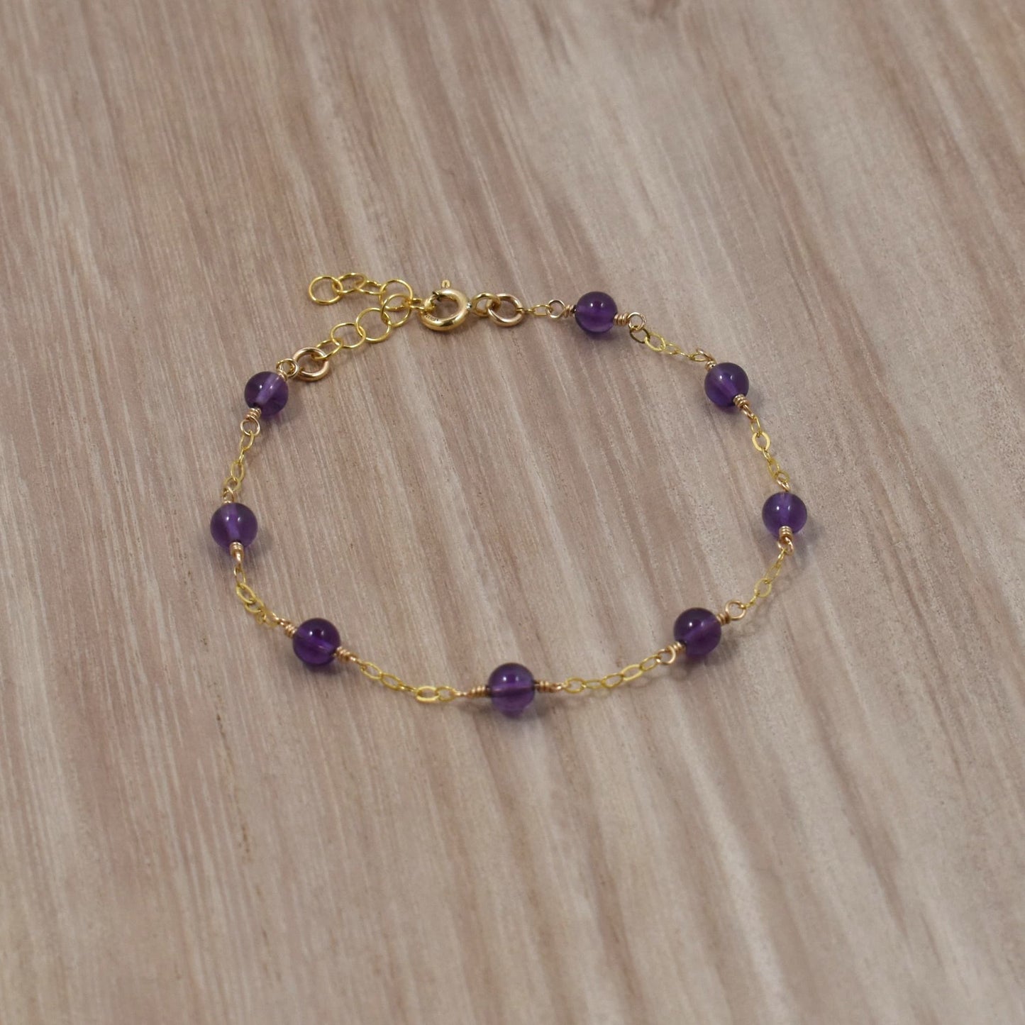 Amethyst bead bracelet on gold chain.