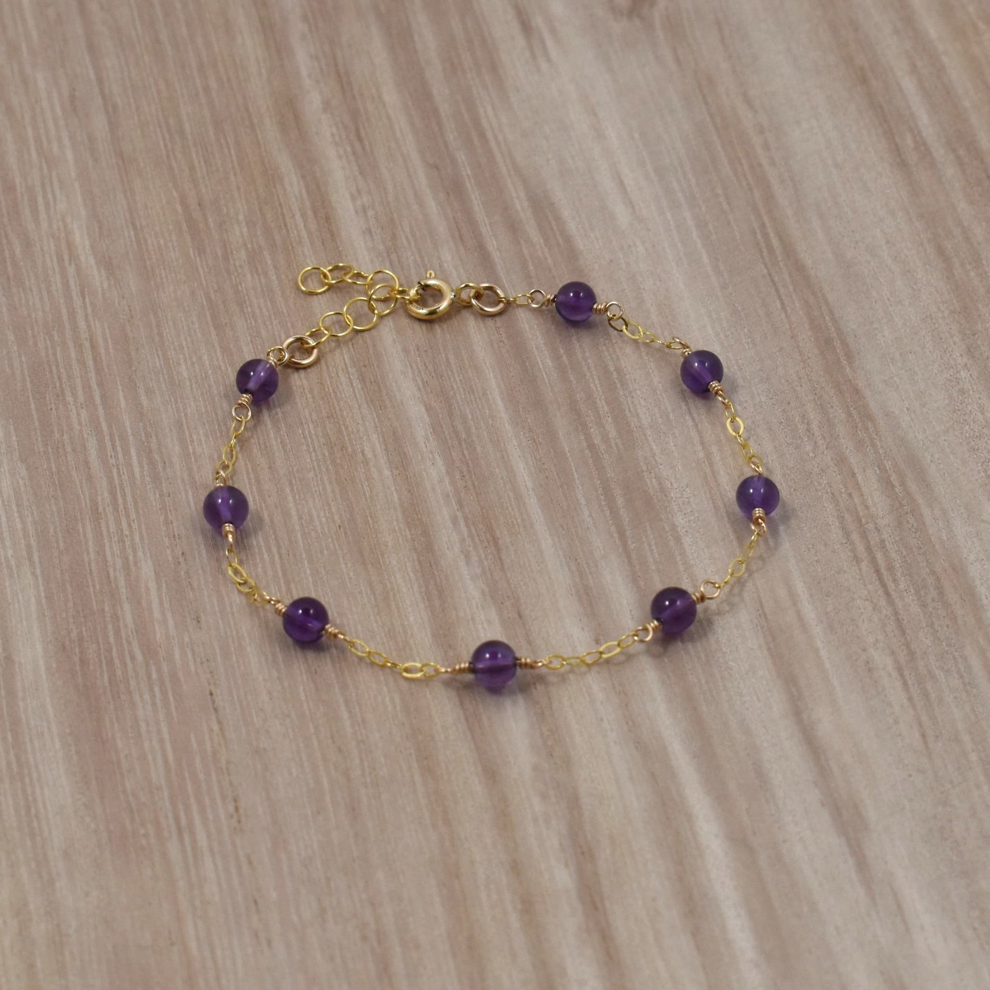 Amethyst bead bracelet on gold chain.