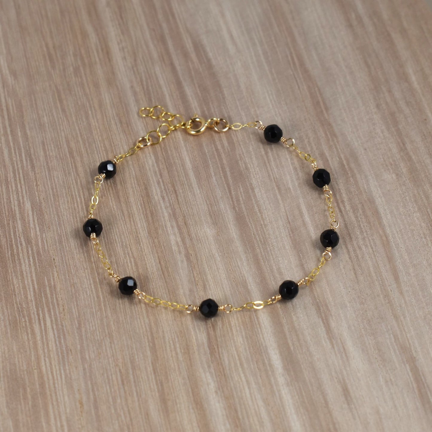 Black onyx bead bracelet with gold chain.