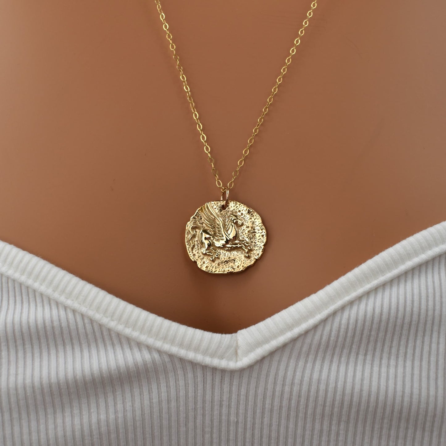 Gold horse pendant necklace showing Pegasus of Greek mythology, product shown on model..