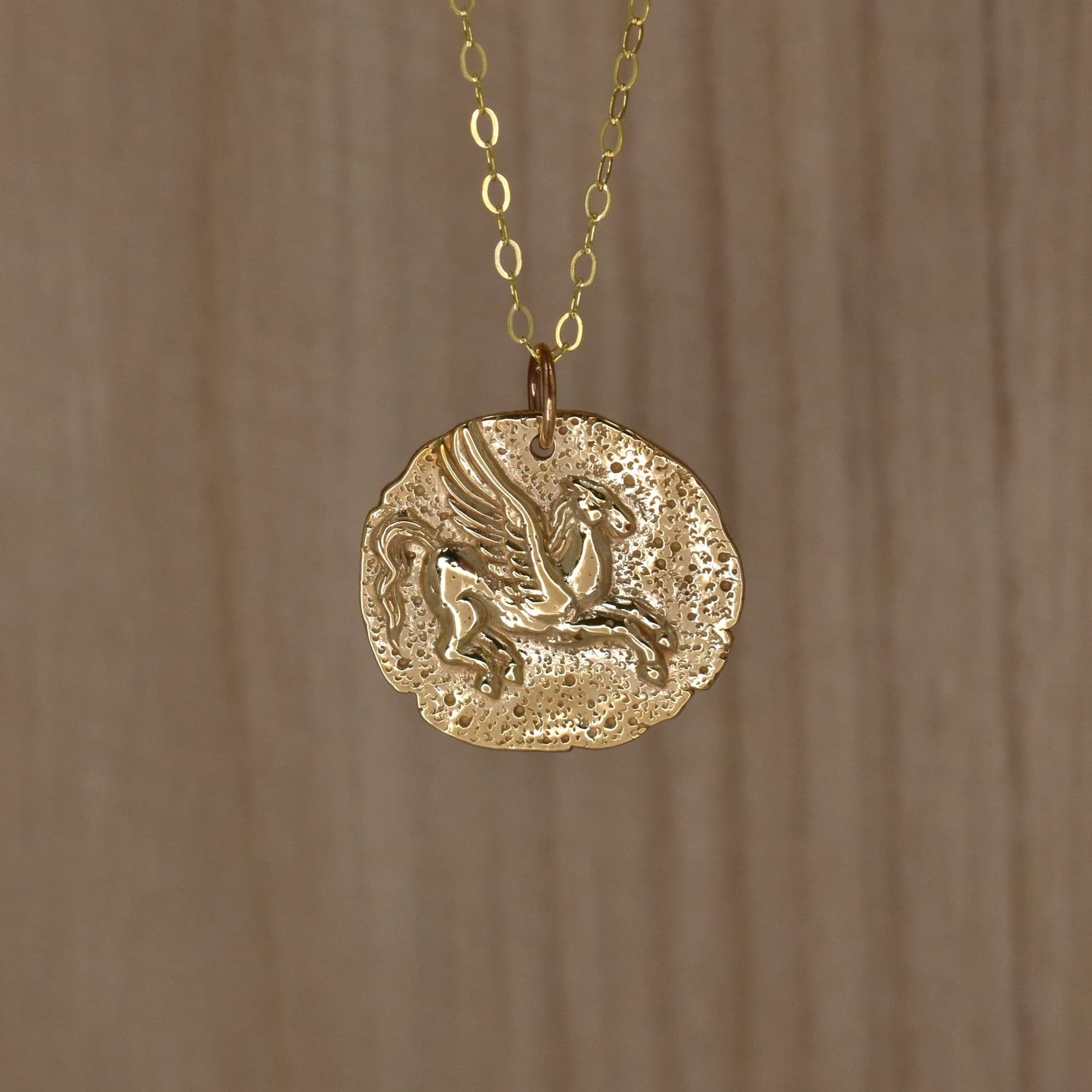 Gold horse pendant necklace showing Pegasus of Greek mythology.