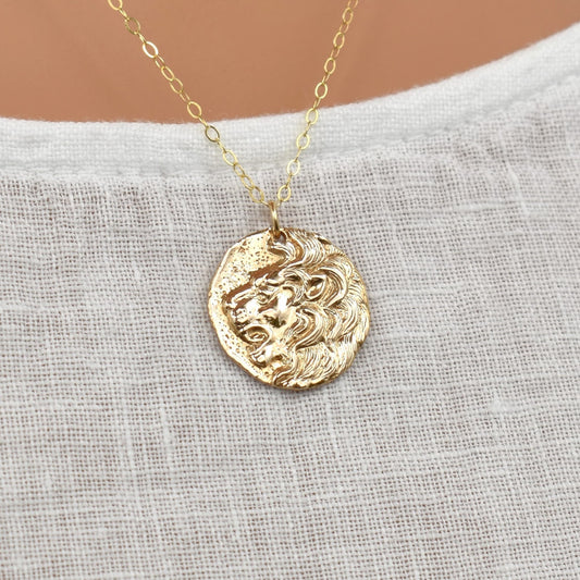 Gold necklace with roaring lion's head pendant.