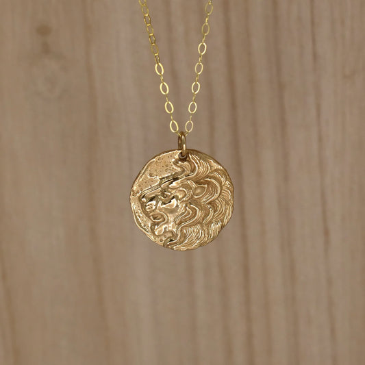 Gold necklace with roaring lion's head pendant.