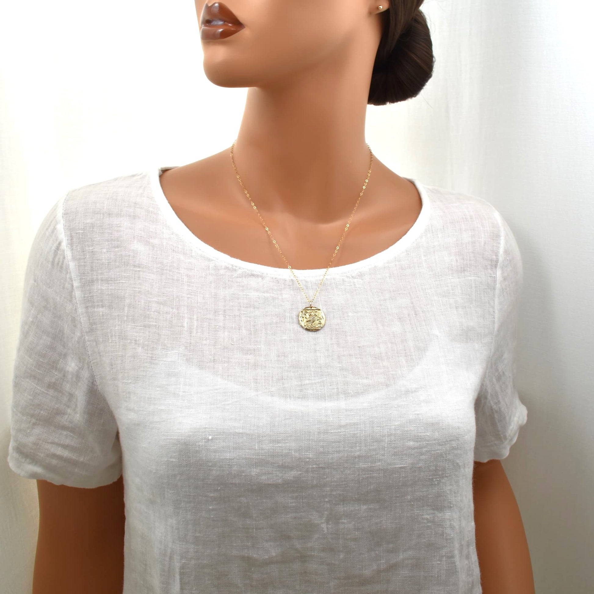 Gold owl pendant necklace with symbol of Greek goddess Athena, 22 inches, shown on female model.