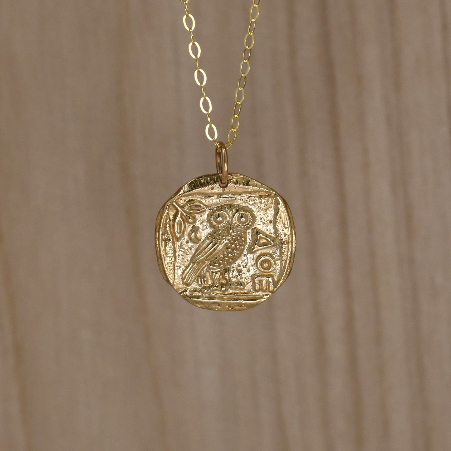 Gold owl pendant necklace with symbol of Greek goddess Athena.