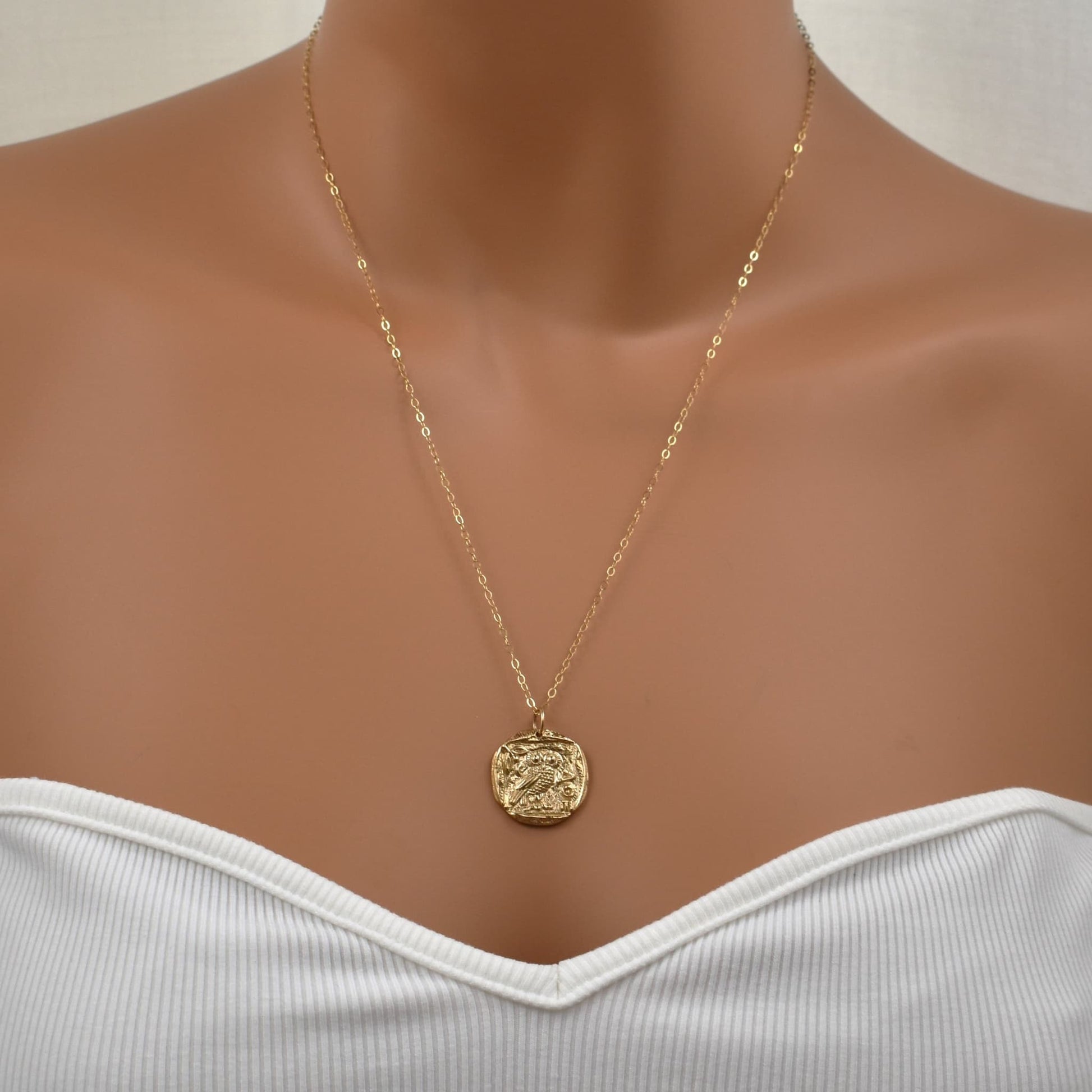 Gold owl pendant necklace with symbol of Greek goddess Athena shown on model.