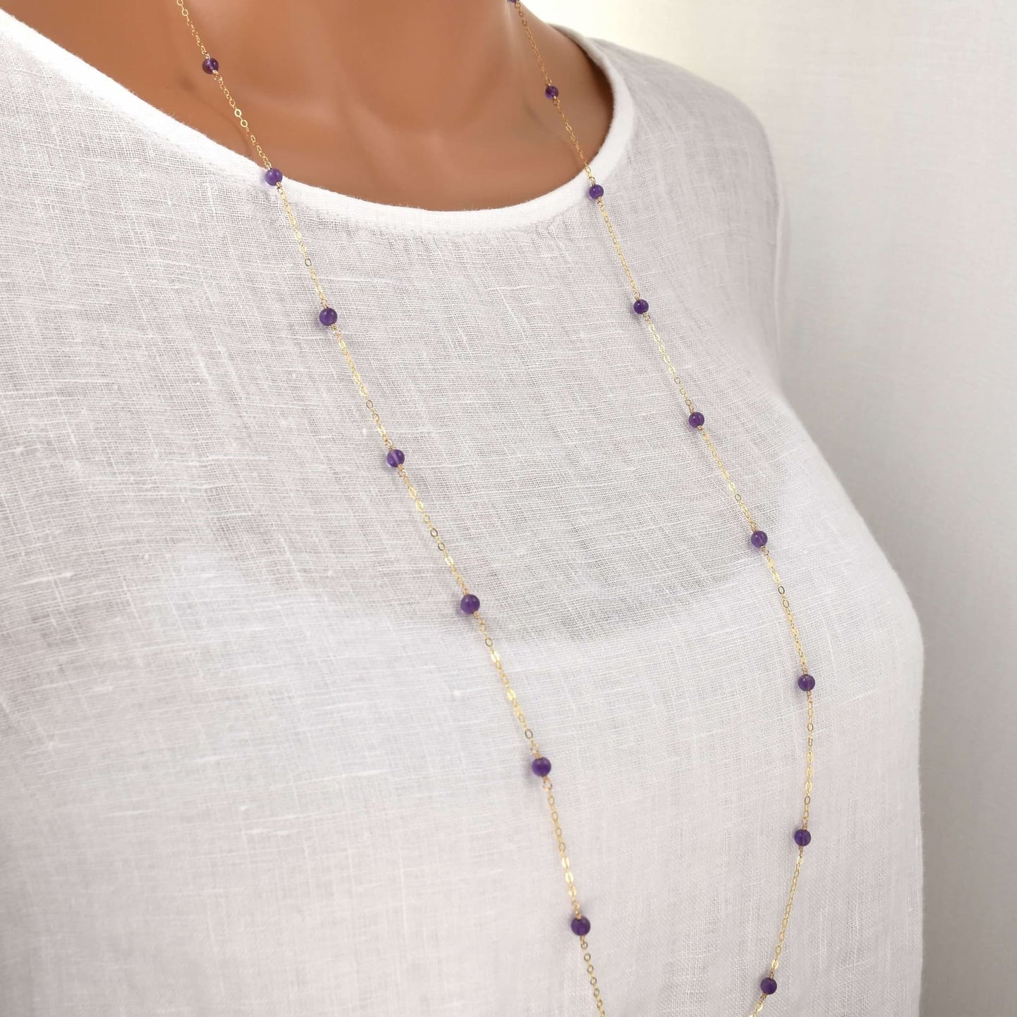 long gold necklace with small amethyst beads spaced evenly along the chain, 36 inches long