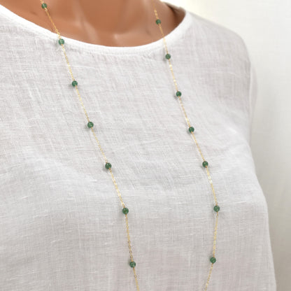 Long gold necklace with green aventurine beads spaced evenly on a fine chain.