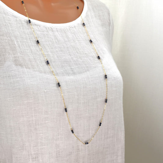 Long gold necklace with small sapphire beads spaced evenly on a fine chain, 36 inches long