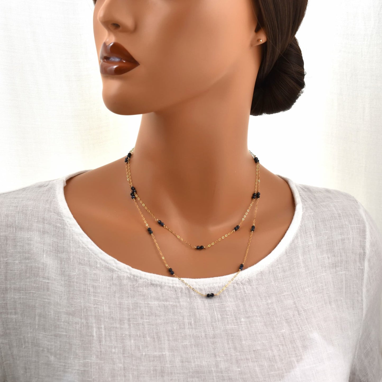 Long gold necklace with small sapphire beads spaced evenly on a fine chain, 36 inches long