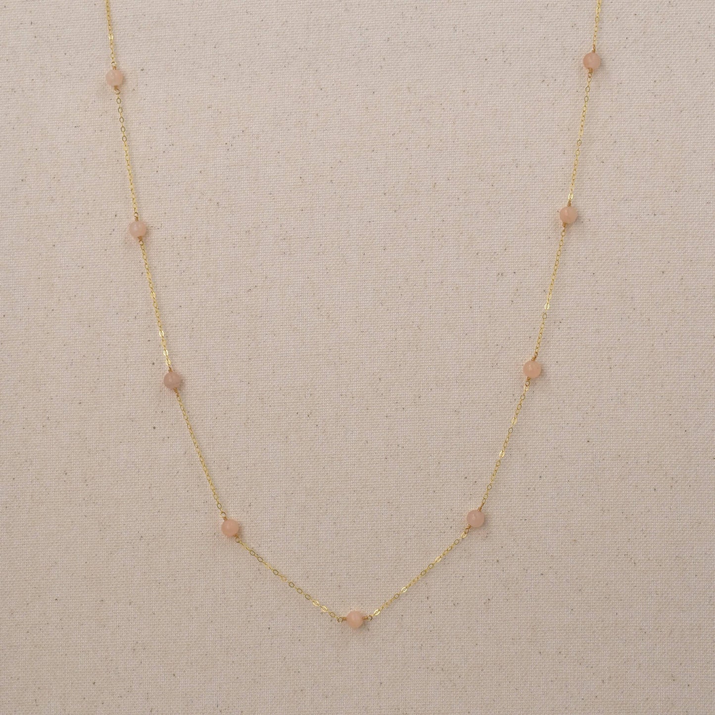 Long gold necklace with pink peach quartz gemstones