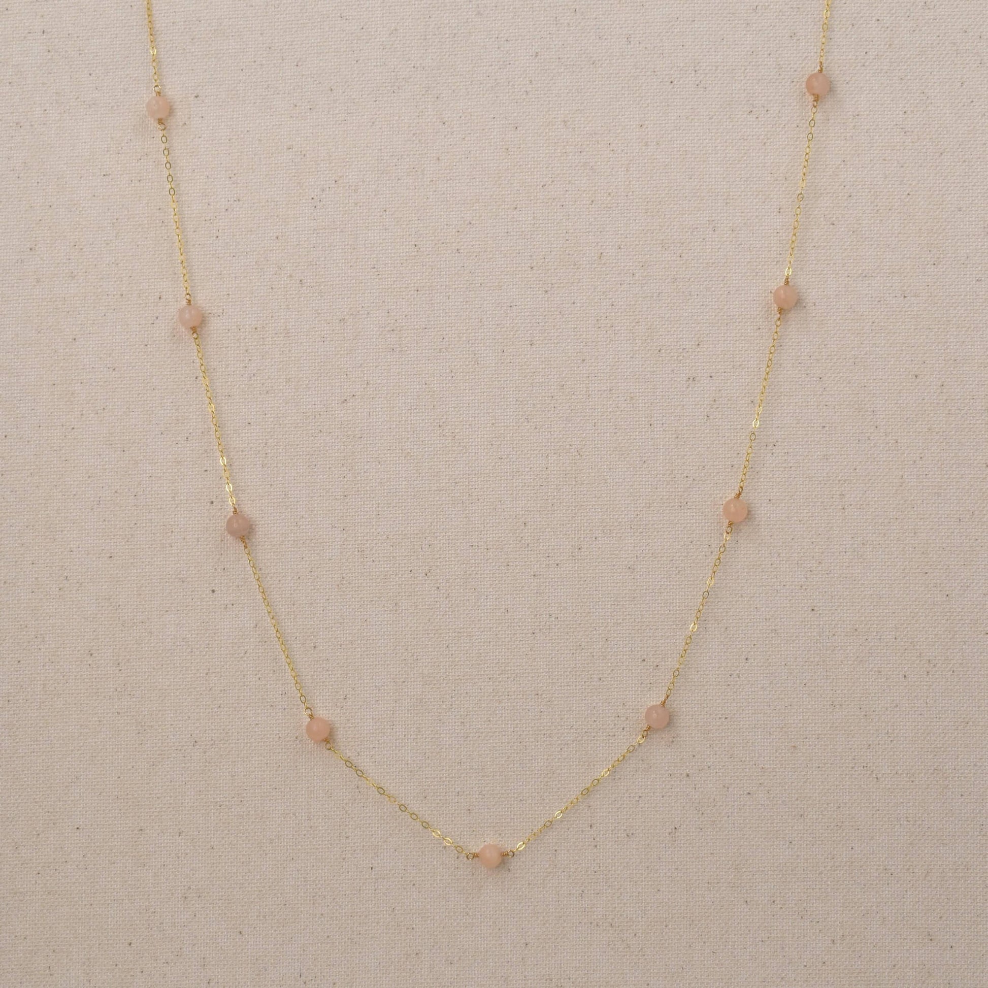 Long gold necklace with pink peach quartz gemstones