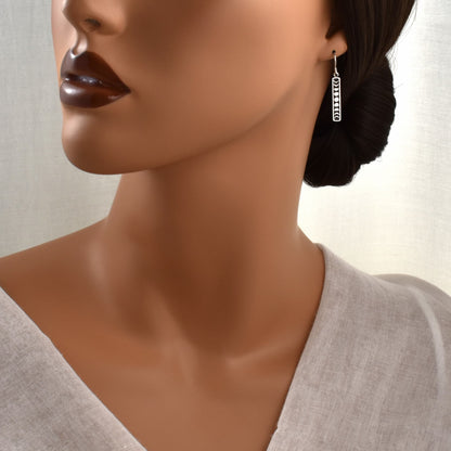 silver moon phase dangle earrings shown on model.