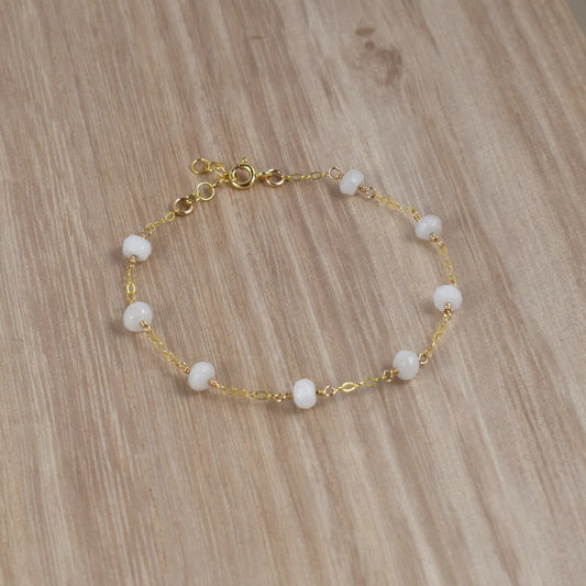 White quartz bead bracelet on gold chain.